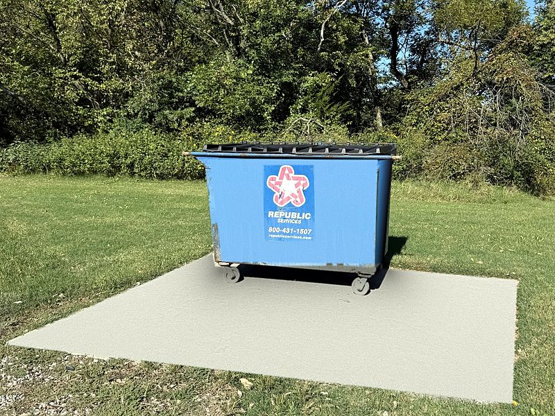 Trash dumpster on a concrete pad